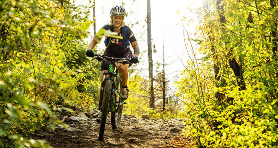 woman mountain biking on trail