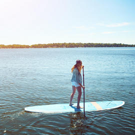 woman paddleboarding on lake