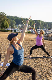 women doing yoga on fontana beach