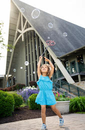 girl playing with bubbles in front of a-frame
